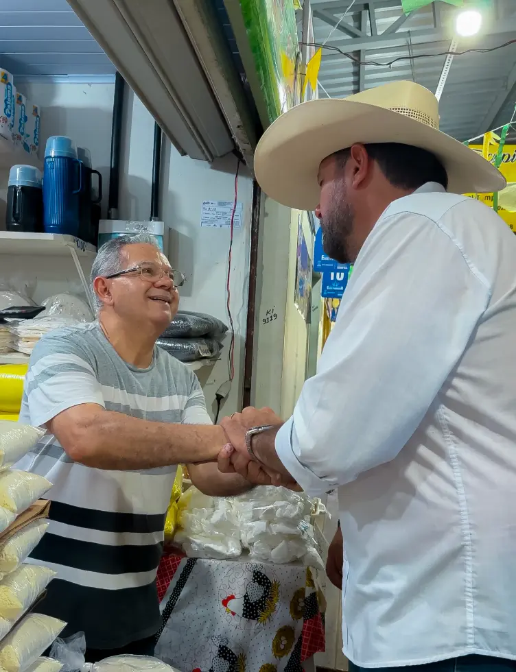 Júnior Betão cumprimentando um comerciante no mercado